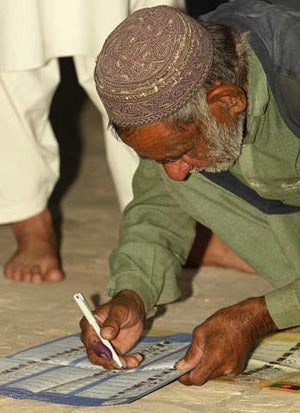 An Afghan man marking his ballot at a polling site in Herat. (c) 2005 Reuters/Caren Firouz