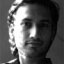 [An image of Tasneem Khalil. He's young, maybe in his late twenties or early thirties, with a mop of curly hair and a slightly scruffy chin.]