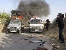 An ambulance passes by the burning vehicle of Reuters cameraman Fadel Shana after he was killed in Gaza on April 16, 2008. � 2008 Reuters