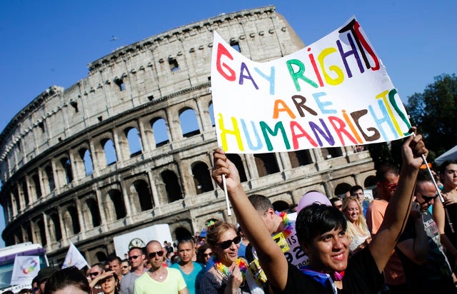 Una donna con un cartello davanti al Colosseo durante il gay pride del 15 giugno 2013 a Roma.  © 2013 Reuters