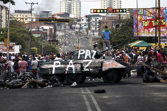 <p><p>Opposition supporters stand over a tank in San Cristobal, Venezuela on February 19, 2014.</p></p>