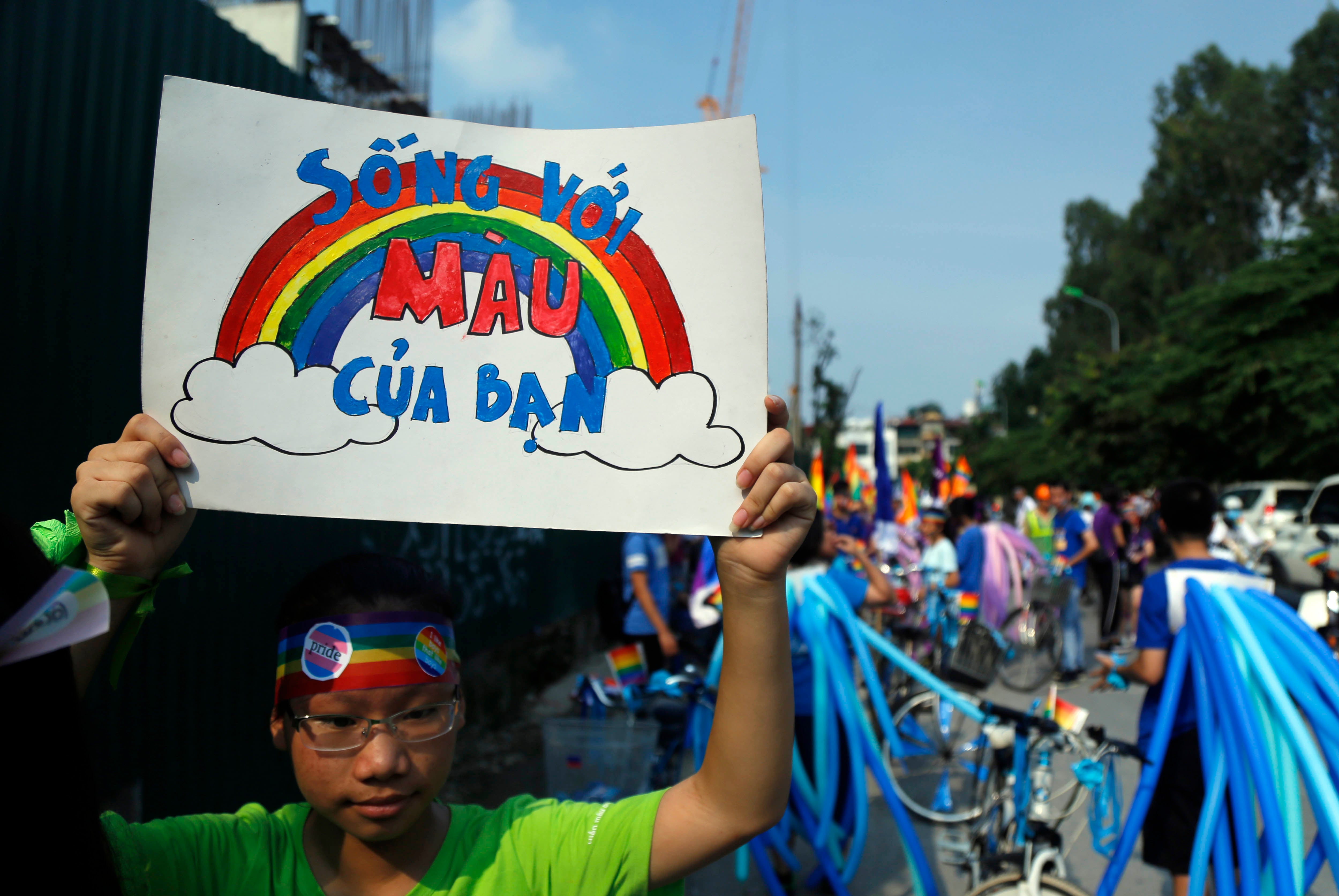  Seorang pesepeda membentangkan poster berbahasa Vietnam, "Pancarkan warna sejatimu," menjelang sebuah ajang balap sepeda di Hanoi, Vietnam, 24 September 2017. © 2017 AP Photo/Hau Dinh