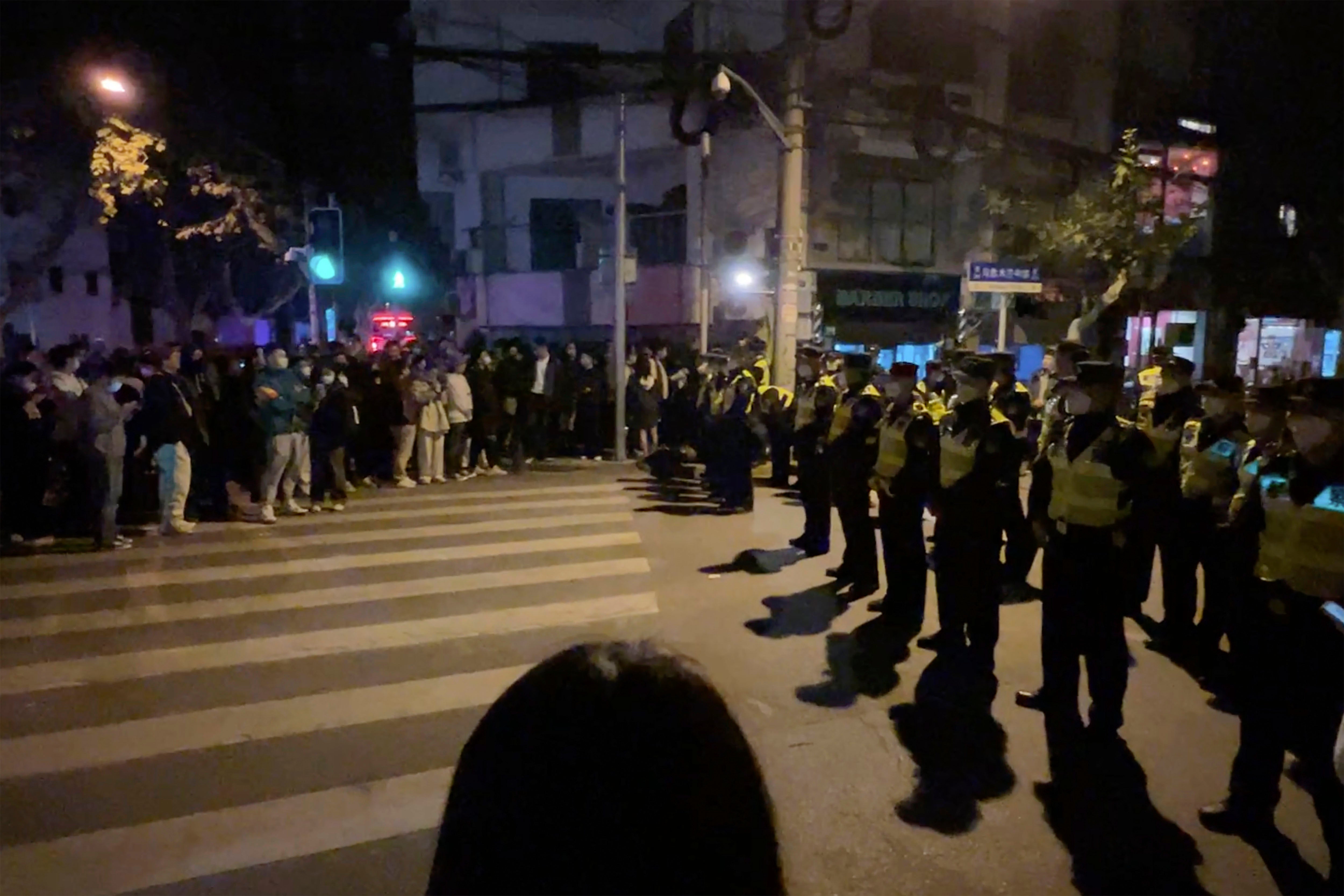 Agentes de la policía bloquean el acceso a un lugar donde se habían reunido los manifestantes en Shanghai el 27 de noviembre de 2022.