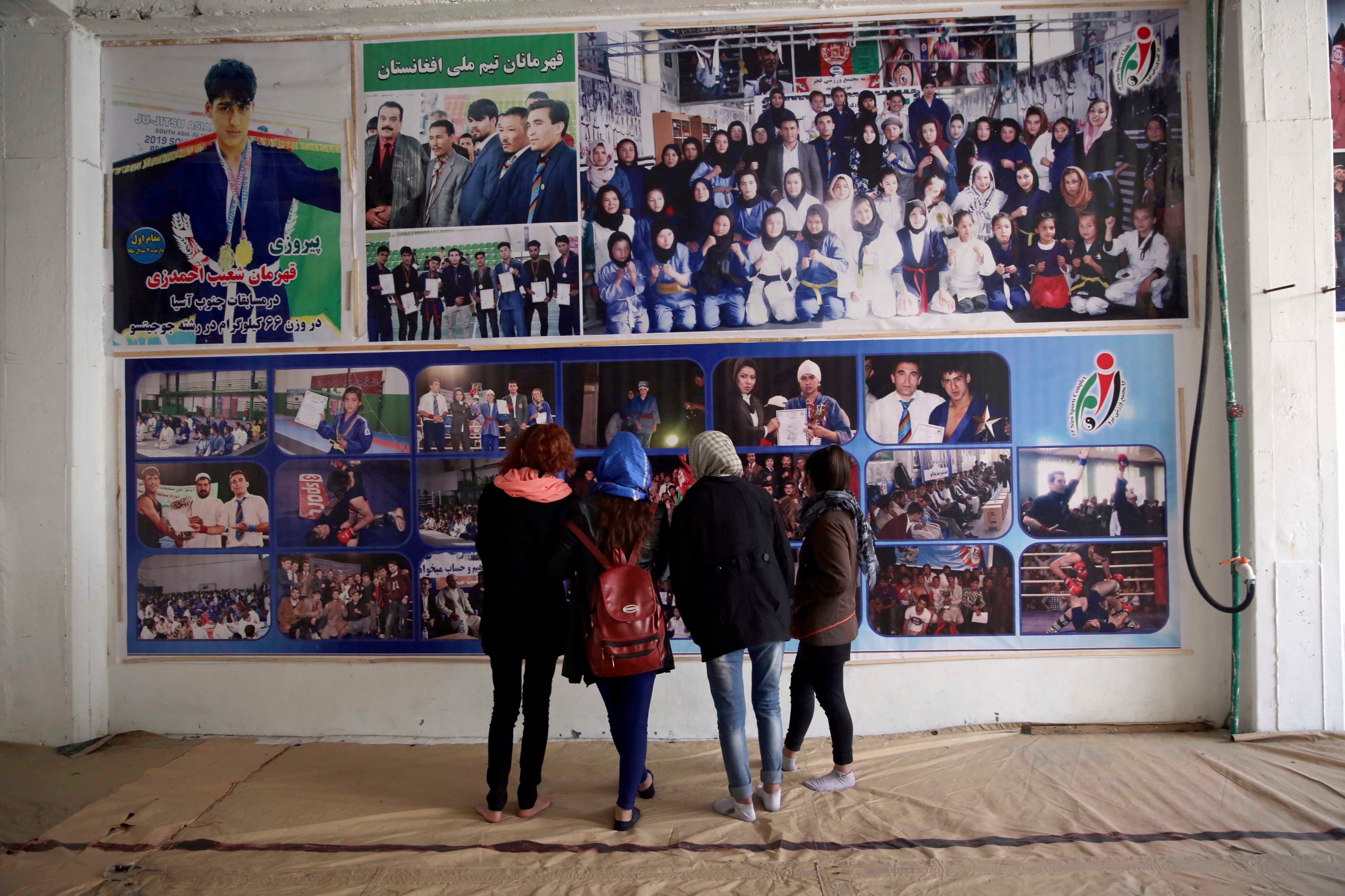 阿富汗喀布尔一家柔术馆学员上课前在门口海报墙驻足，2020年2月15日。