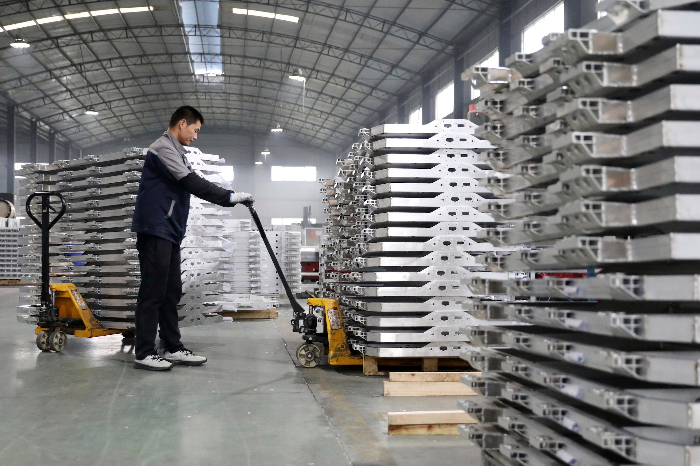 中国安徽省一家汽车制造厂，员工正在搬运铝制零件，2022年3月26日。