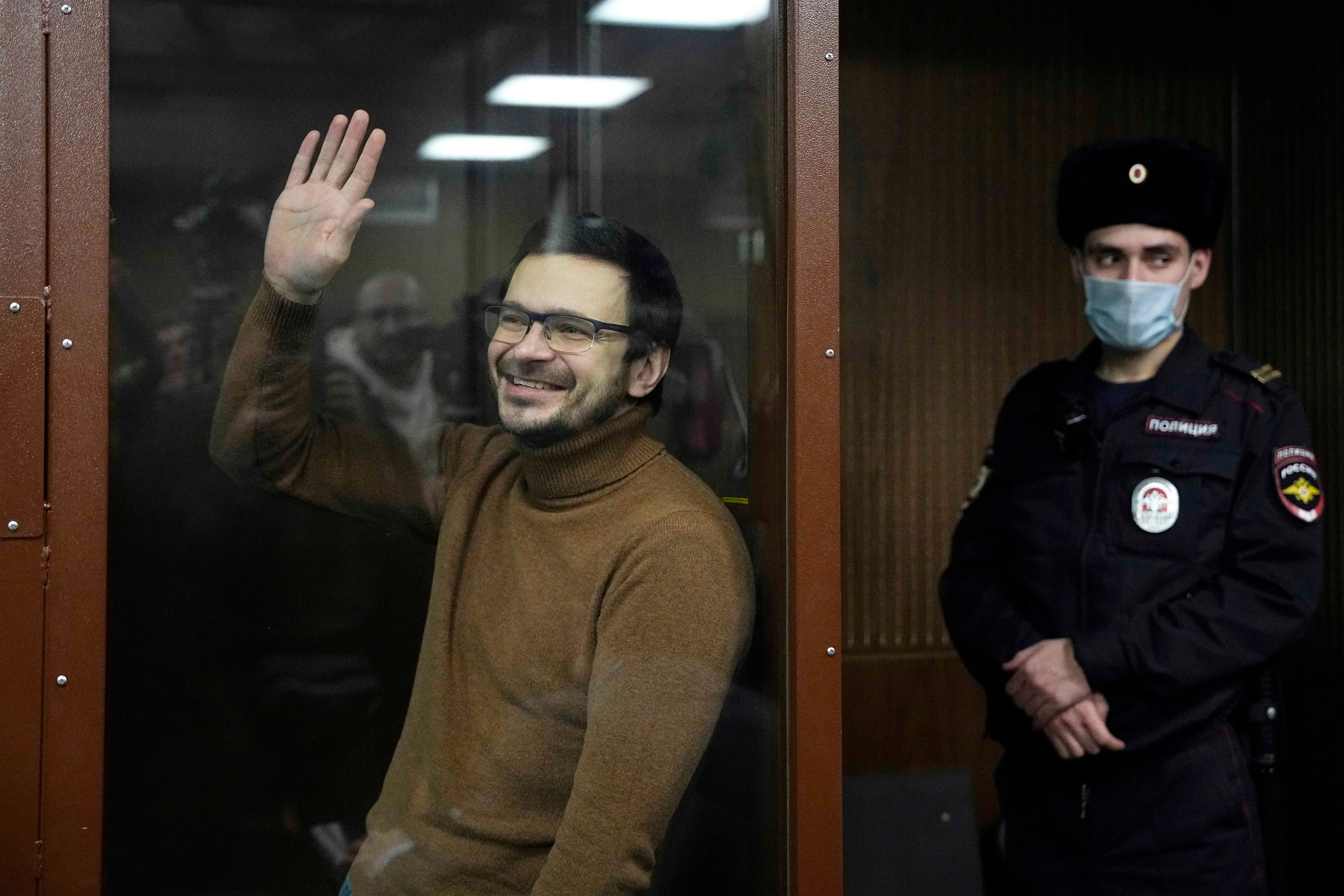 Ilya Yashin waves to supporters in a Moscow courtroom during a hearing on abusive charges against him of spreading "false information" about Russian forces. Moscow, Russia, November 29, 2022. 