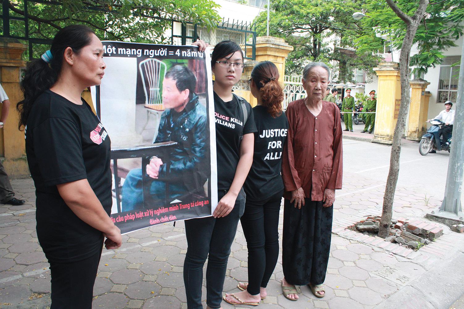 The family of Trinh Xuan Tung (his mother Nguyen Thi Cuc, his wife Nguyen Thi Mien, and his two daughters Trinh Kim Tien and Trinh Cam Tu) outside the court on July 17, 2012, waiting to attend appellate proceedings in the trial of former Coronel.