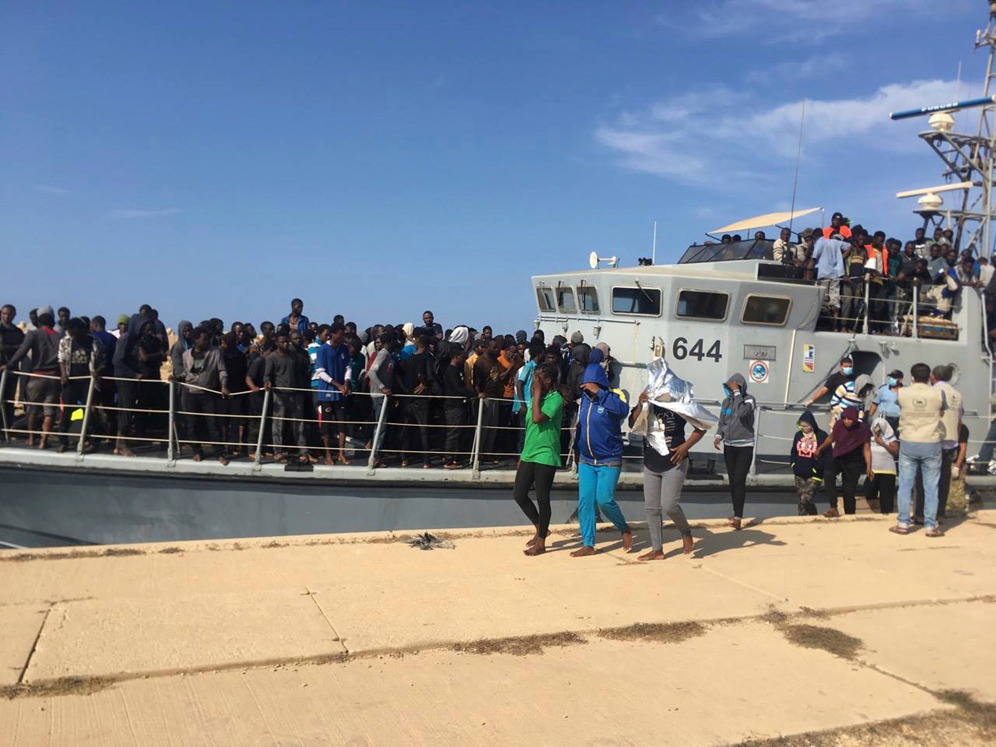 Foto rilasciata dalla Guardia Costiera libica che mostra persone che sbarcano in Libia dopo essere state intercettate a largo, il 24 giugno 2018.