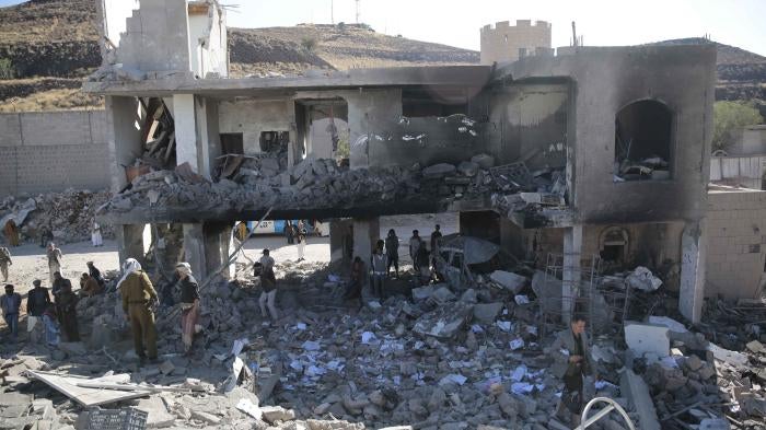 People inspect a damaged building in Sanaa, Yemen.
