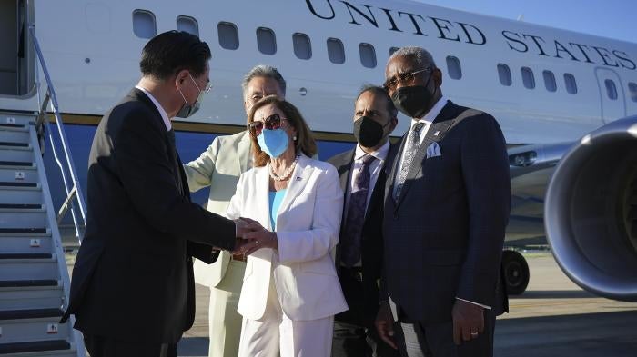 Taiwan's Foreign Minister Joseph Wu, left, speaks with US House Speaker Nancy Pelosi in front of a plane