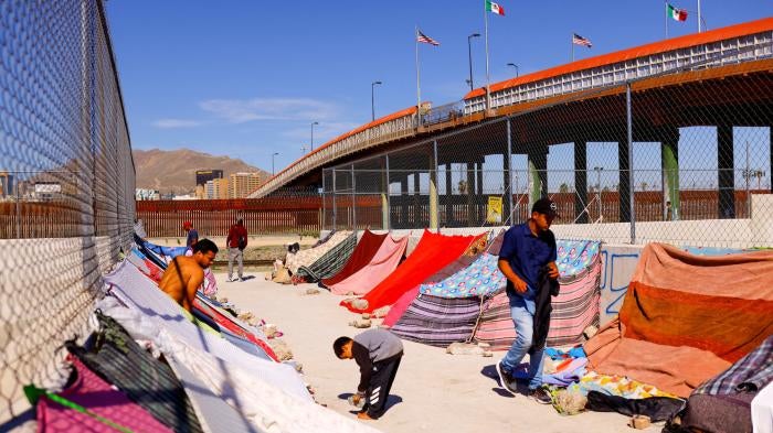 Venezuelan migrants stand near the Paso del Norte International Bridge, in Ciudad Juarez, Mexico.
