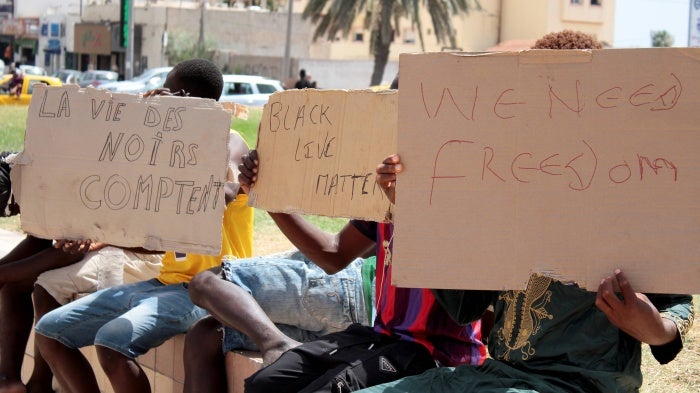 Migrants hold placards reading "Black Lives Matter", left in French, during a gathering in Sfax, Tunisia's eastern coast, on July 7, 2023.