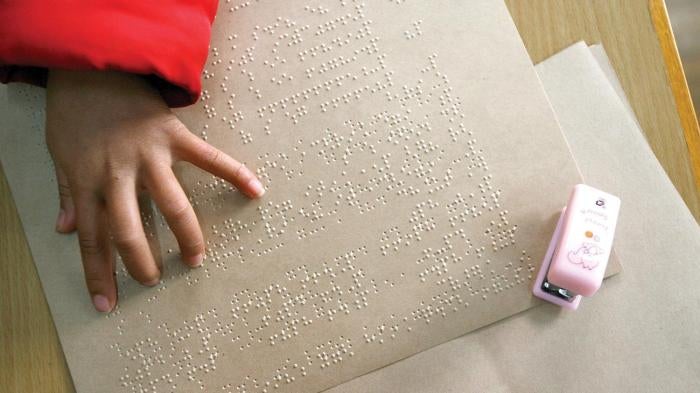 A blind girl reads Braille text in her class at the Shanghai School for the Blind in Shanghai.