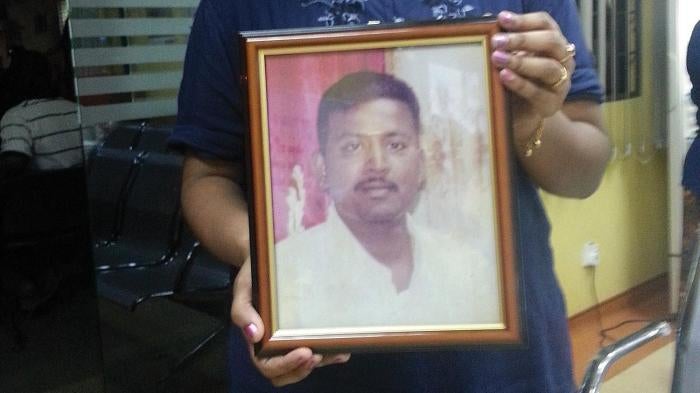 Marry Mariasusay holds a photo of her late husband, Dhamendran Narayanasamy, at the Kuala Lumpur Hospital morgue on May 22, 2013.