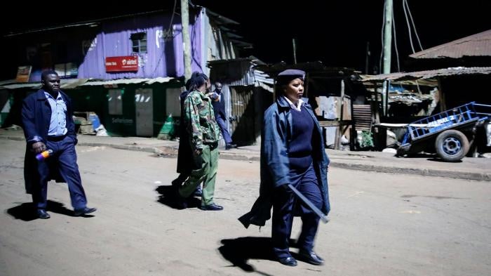 Kenyan police carrying batons and teargas patrol looking for people out after curfew in the Kibera slum, or informal settlement, of Nairobi, Kenya, March 29, 2020.