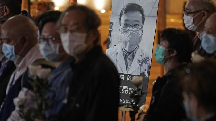 People wearing masks, attend a vigil for Chinese doctor Li Wenliang, in Hong Kong, February 7, 2020.