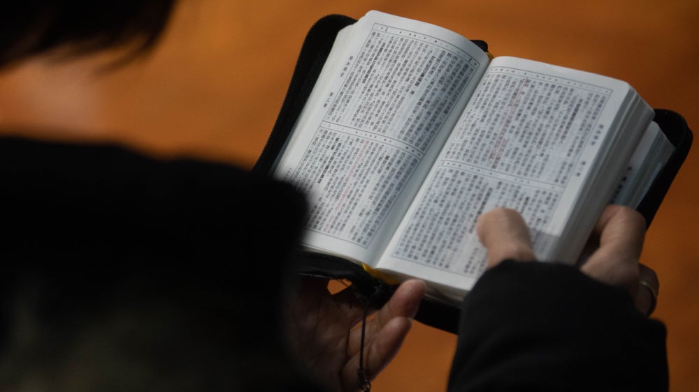A church member reads a bible during a service in Hong Kong in solidarity with the Early Rain Covenant Church in China, whose members face persecution, December 18, 2023. 