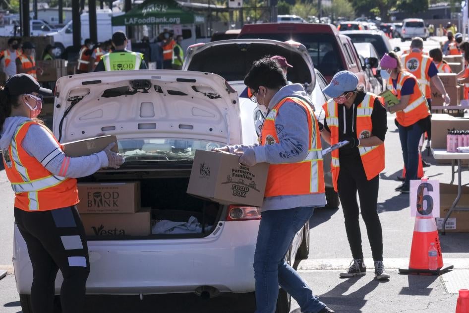 Voluntarios ponen alimentos en el maletero de automóviles durante la campaña de distribución vehicular de alimentos “Let’s Feed LA County” organizada por Los Angeles Regional Food Bank y la Oficina de la Supervisora Hilda Solís el 23 de febrero de 2021, en La Puente, California. 