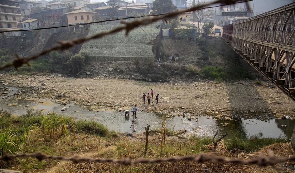 People cross the Tiau River which forms the India-Myanmar border in Mizoram, India, March 20, 2021.