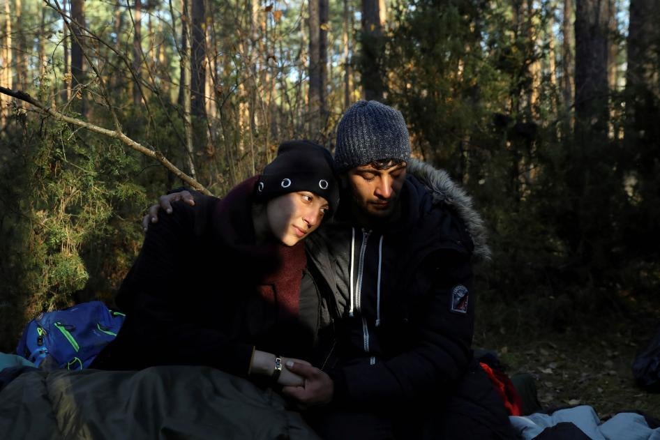 A szíriai 26 éves Sara és a 24 éves Hassan a lengyelországi Lewosze erdőjében ülnek a földön, miután átlépték a fehérorosz határt 2021. október 29-én.