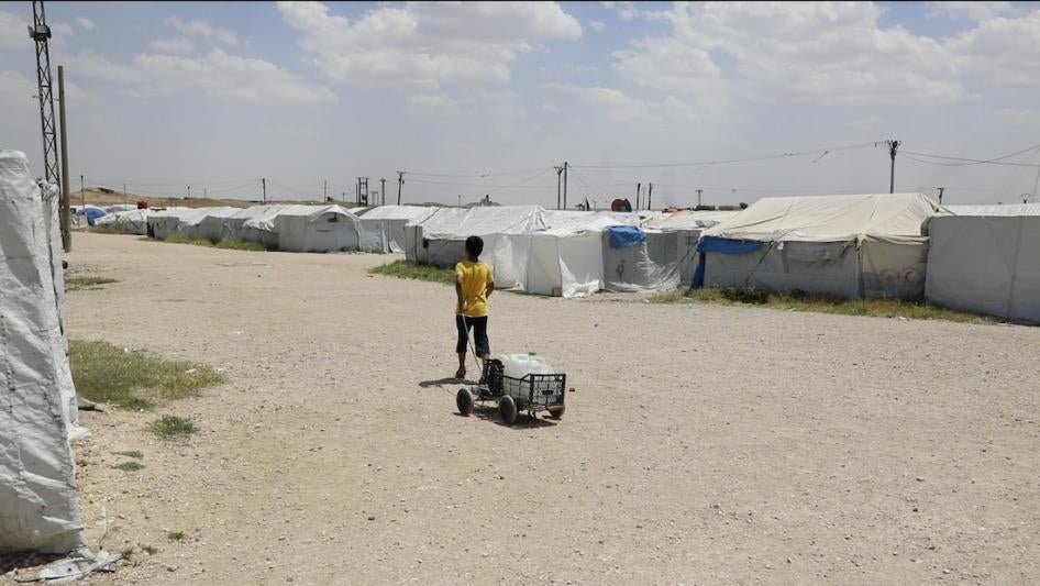 Een jongen sjouwt met een water container in kamp-Roj in het noordoosten van Syrië, Mei 2022. 