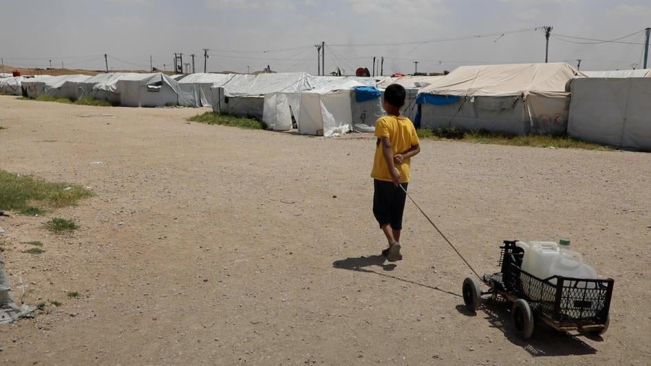 A boy lugs water in Roj camp in northeast Syria, May 2022.  2022 San Saravan for HRW
