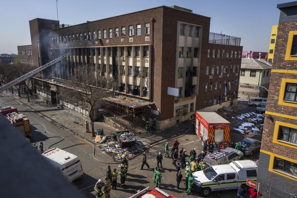 Medics stand by a burning apartment block in Johannesburg on August 31, 2023.