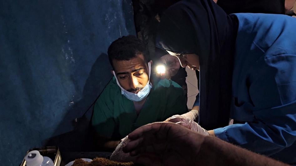 אנשי צוות רפואי מטפלים בפלסטיני שנפצע בתקיפה ישראלית לאור פנסים בשל המחסור בחשמל בבית החולים האינדונזי שבצפון רצועת עזה, 10 בנובמבר 2023.
