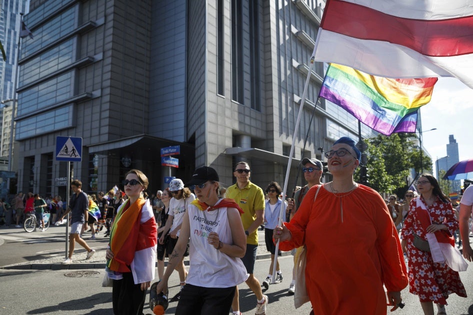 Des militants LGBTQ biélorusses portant des drapeaux blanc-rouge-blanc participent à la parade de l'égalité de Varsovie, le 25 juin 2022.