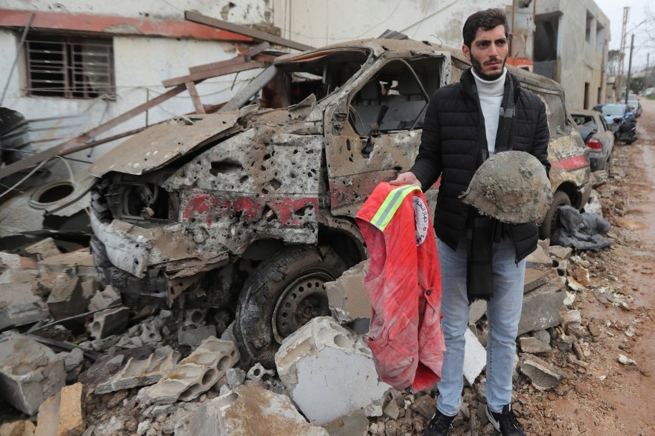 אדם אוחז בחפציו של חובש שנהרג בתקיפה ישראלית על מרכז סיוע בהבארייה, דרום לבנון, ב-27 במארס 2024, בתמונה שצולמה ביום התקיפה. 
