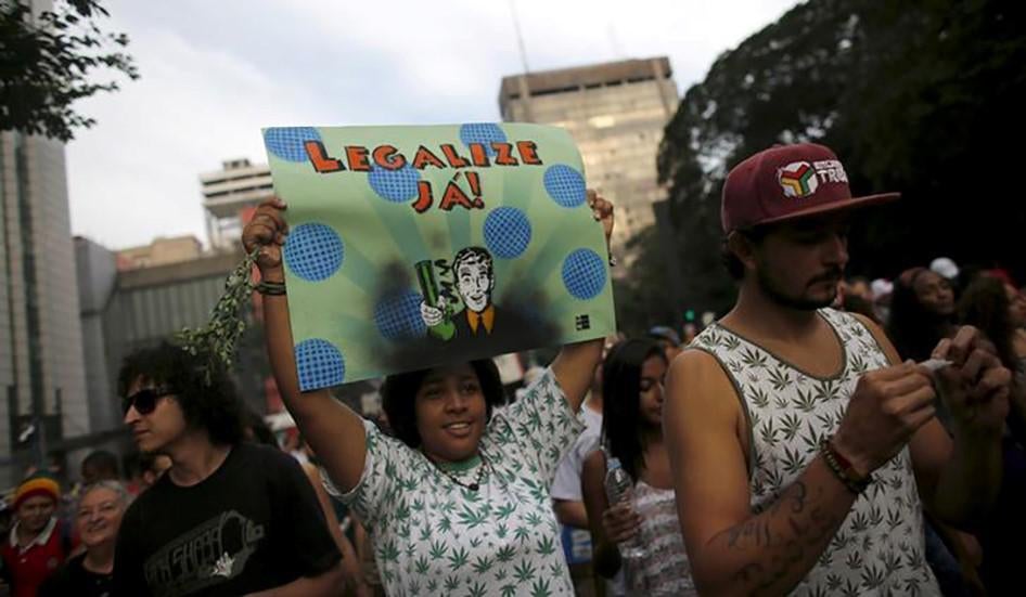 Uma mulher segura um cartaz com o escrito "legalize já" durante uma marcha de apoio a legalização do uso de cannabis em São Paulo, Brasil. 23 de maio de 2015.