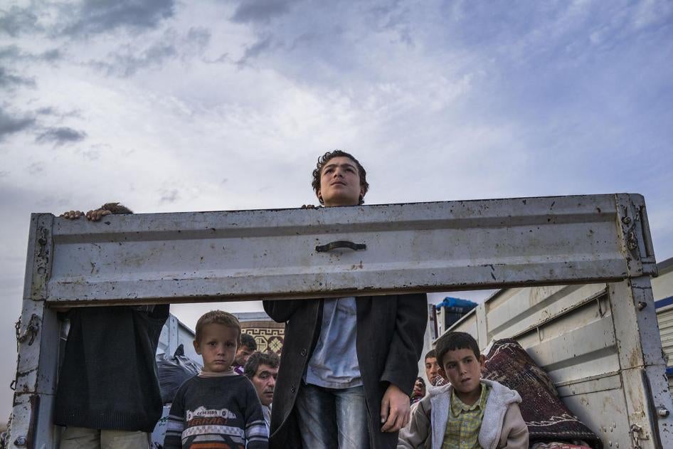 SEPTEMBER 2014. Syrian Kurdish refugees look out from the back of a truck as they enter Turkey from the town of Kobane  (Ayn al-Arab), Syria, and surrounding villages.   © 2014 Michael Christopher Brown/Magnum