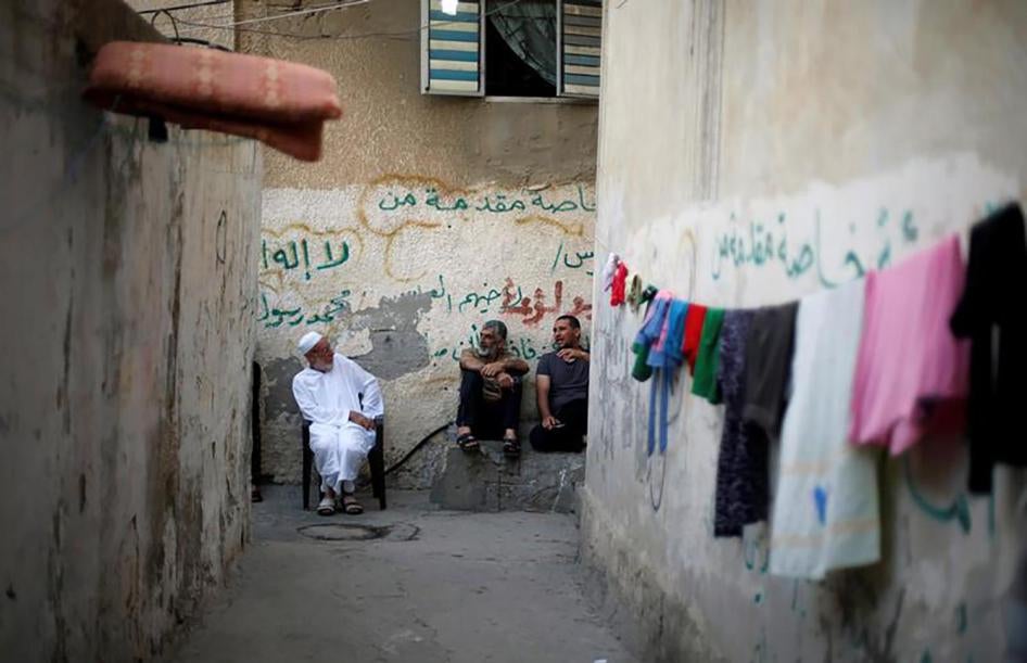 פלסטינים יושבים מחוץ לבתיהם כדי להימלט מהחום, במהלך הפסקת חשמל במחנה הפליטים שאטי שברצועת עזה.