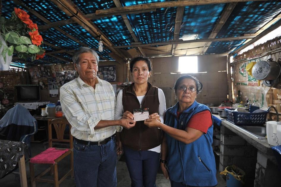Antenor Hoyos Cubas et sa femme María Concepción Sagastegui Tapia, photographiés avec leur fille dans leur maison dans la banlieue de Lima (Pérou) en mai 2017, tiennent une photo de leur fils Nestor, 25 ans après sa « disparition forcée » aux mains de sol