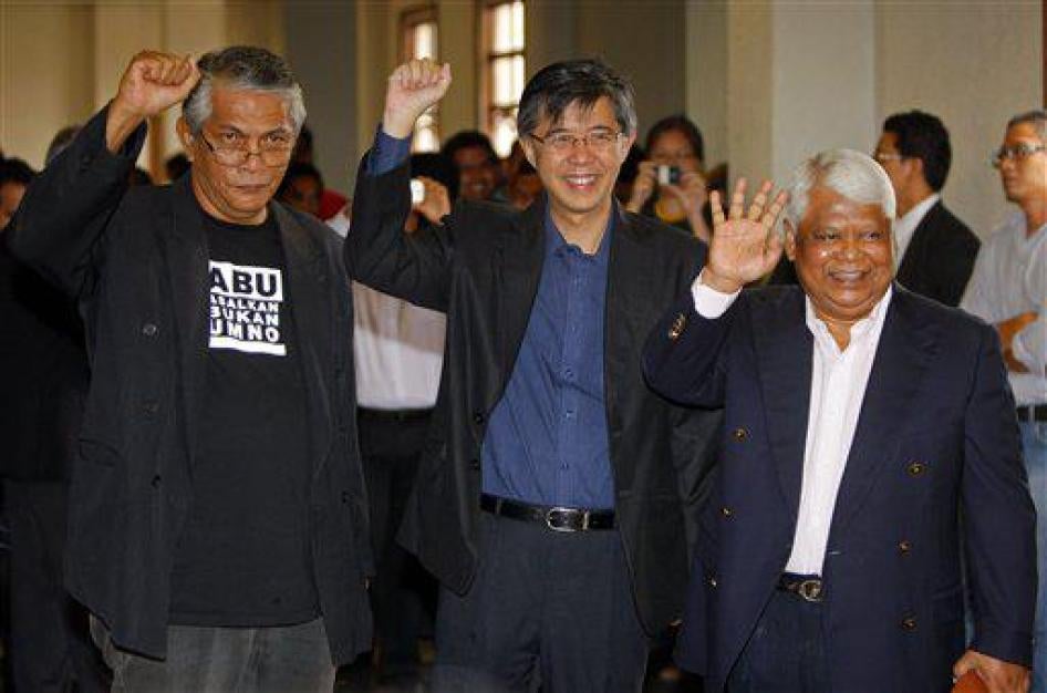Aktivis sosial Haris Ibrahim (kiri) pemimpin oposisi Tian Chua (tengah) dan aktivis Partai Islam Pan-Malaysia Tamrin Ghafar berpose di hadapan para fotografer saat mereka tiba di sebuah gedung pengadilan di Kuala Lumpur, Malaysia, Rabu, 29 Mei 2013. 