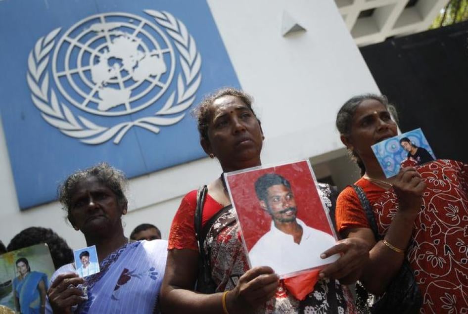 Sri Lankan Tamil women hold up photographs of their missing family members as they wait to hand over a petition to the U.N. head office in Colombo March 13, 2013. 