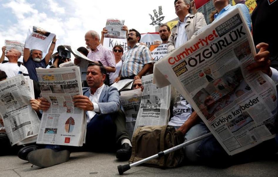 Para aktivis kebebasan pers membaca koran oposisi Cumhuriyet dalam sebuah aksi demonstrasi wujud solidaritas pada wartawan-wartawan Cumhuriyet yang dipenjara, di luar gedung pengadilan di Istanbul, Turki, 28 Juli 2017.