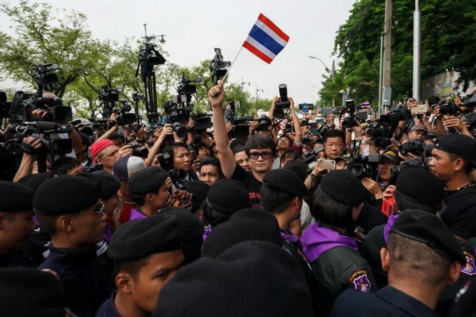 รังสิมันต์ โรม นักกิจกรรมที่เรียกร้องประชาธิปไตย (กลาง) โบกธงชาติไทยในขณะที่ผู้ประท้วงต่อต้านรัฐบาลรวมตัวกันเรียกร้องให้รัฐบาลทหารจัดการเลือกตั้งในเดือนพฤศจิกายน ที่กรุงเทพฯ ประเทศไทย วันที่ 22 พฤษภาคม 2561 
