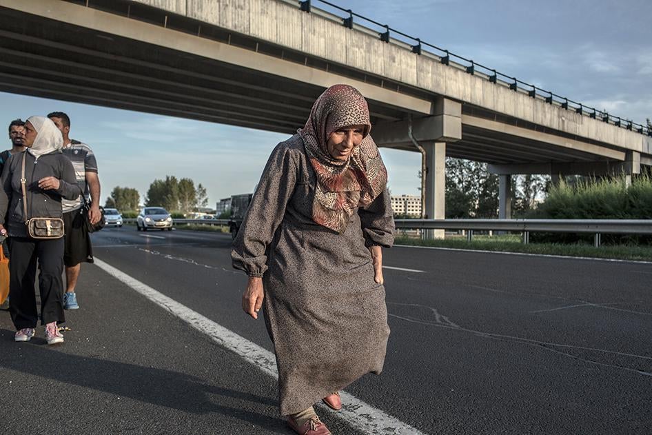 An elderly refugee walks along the Hungarian M1 highway near Budapest, Hungary, September 4, 2015. 