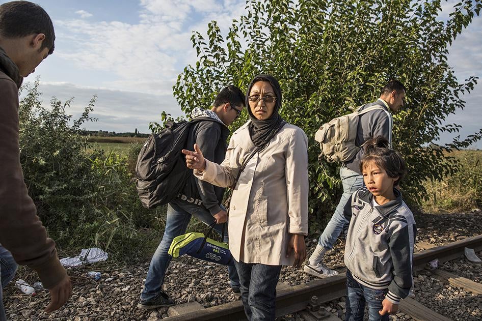 A mother and daughter from Afghanistan wait for two other siblings near Roszke, Hungary after having crossed the Hungarian-Serbian border.  She told Human Rights Watch that regardless of any fences, they would reach their destination. September 8, 2015.