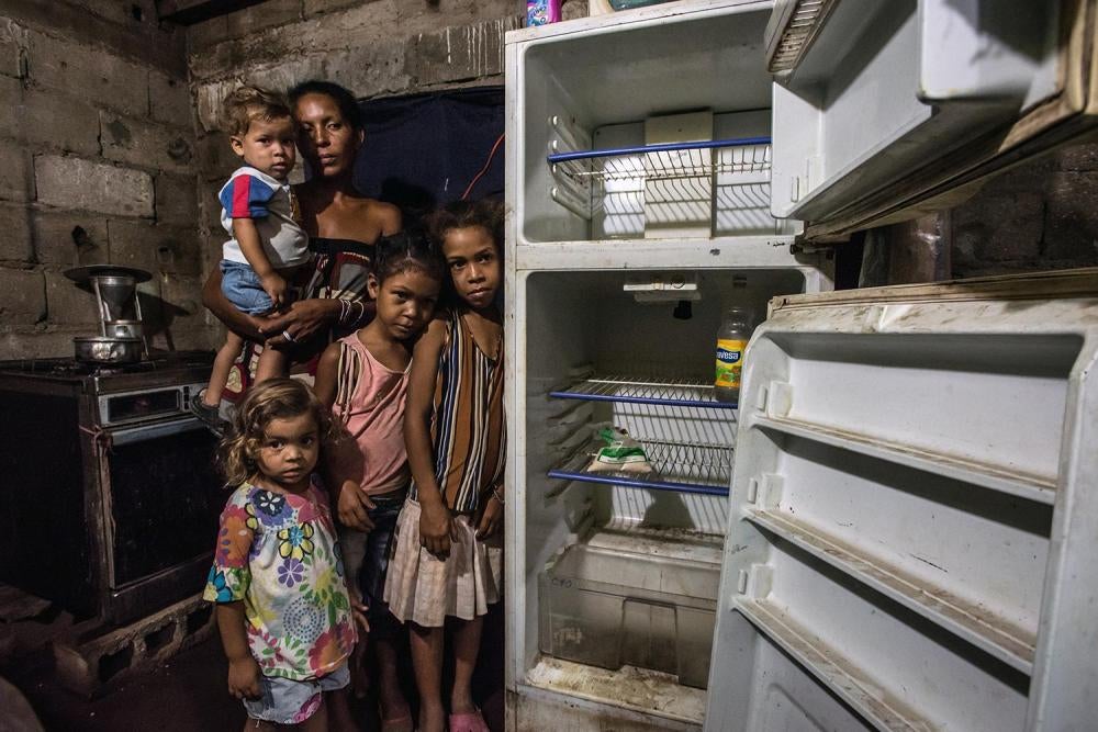Leidy Cordova, de 37 años, con cuatro de sus cinco hijos en su vivienda en Cumaná, Venezuela, 16 de junio de 2016. Su nevera descompuesta contenía los únicos alimentos que había en la casa: una bolsa de harina de maíz y una botella de vinagre.