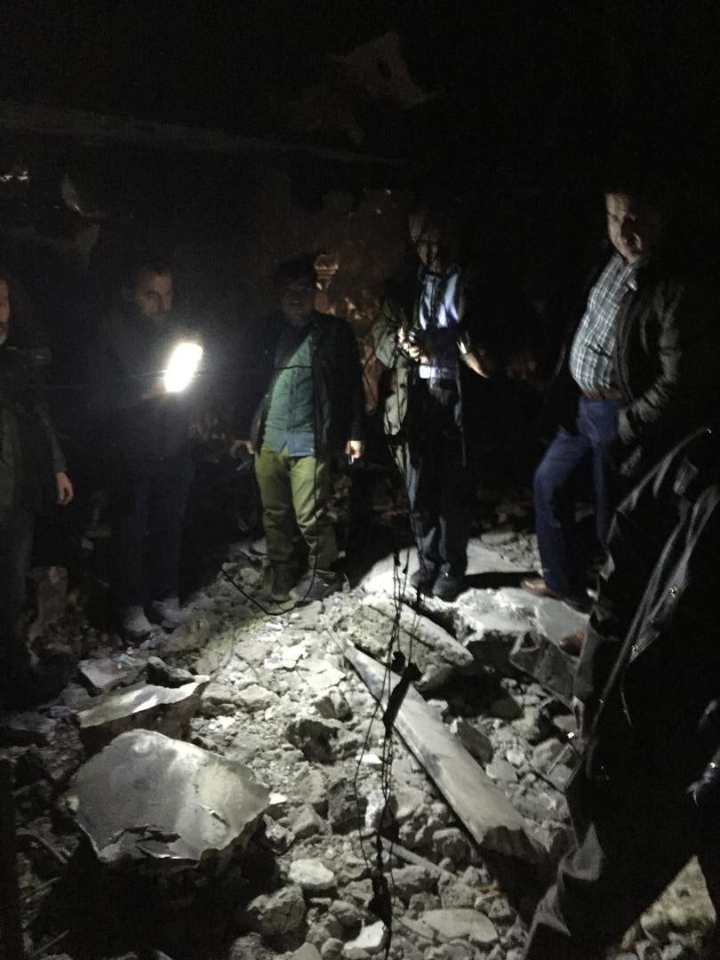 Human rights activists examine charred remains including human bones in a basement where 26 people died after it was stormed by security forces. While the .exact circumstances of the deaths are unclear evidence suggests that they could have been extrajudi