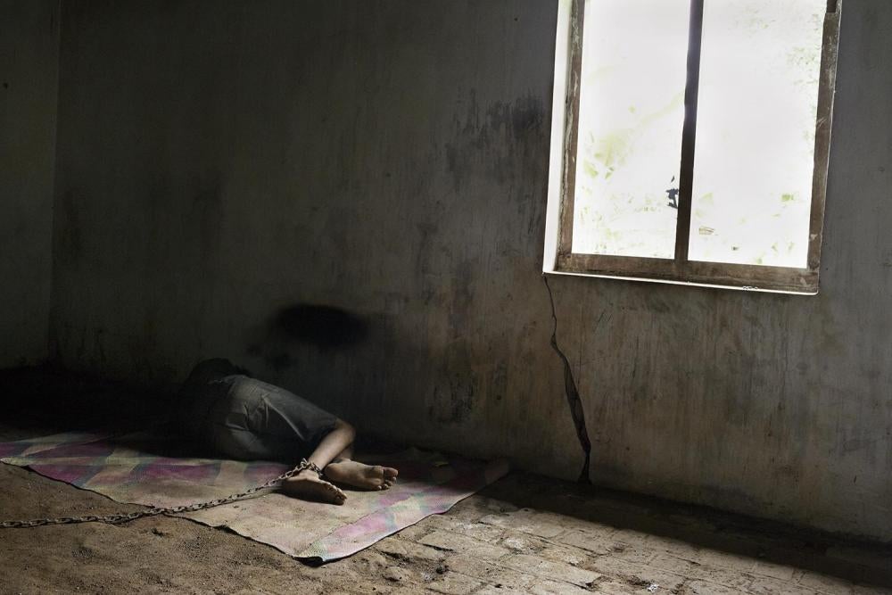 A young man with a psychosocial disability is chained in a back room at his family home in Ponorogo, East Java. 