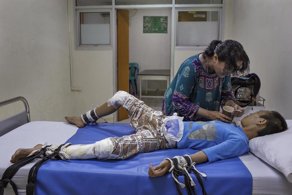 Yeni Rosa Damayanti, pembela hak-hak disabilitas, mengunjungi dan menyuapi seorang remaja perempuan di sebuah rumah sakit jiwa di Jakarta. © 2014 Andrea Star Reese untuk Human Rights Watch