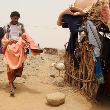 A woman is carried by her brother outside a home in Malus, Yemen. 