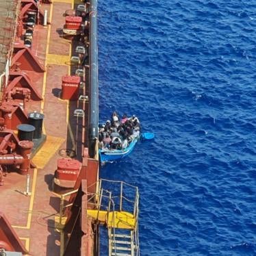 Migrants and refugees sit in a boat alongside the Maersk Etienne tanker off the coast of Malta, in this handout image provided 19 August, 2020.   