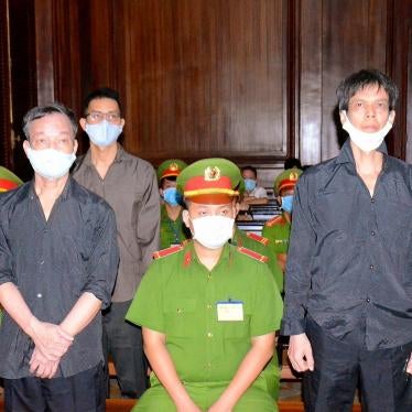 Photo released by the Vietnam News Agency on January 5, 2021 shows Vietnamese bloggers Pham Chi Dung (right), Nguyen Tuong Thuy (front left), and Le Huu Minh Tuan (back left) during their trial in Ho Chi Minh city. 