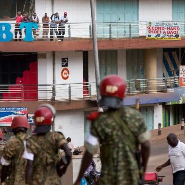 In this file photo, people look down from a balcony as military police deploy in downtown Kampala, Uganda, February 20, 2016. 