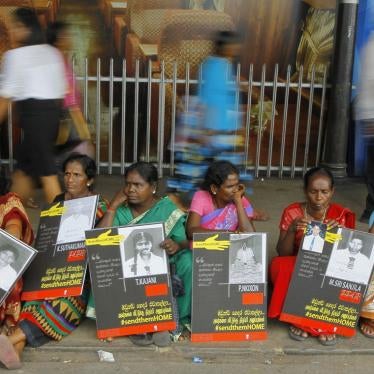 In this April 6, 2015, file photo, Sri Lankan ethnic Tamil women sit holding placards with portraits of their missing relatives as they protest out side a railway station in Colombo, Sri Lanka.
