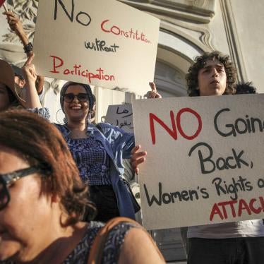 A Tunisian protester holds up a sign that reads, “No going back, women's rights are under attack,” during a protest against president Saied on Avenue Habib Bourguiba in Tunis, on July 22, 2022.